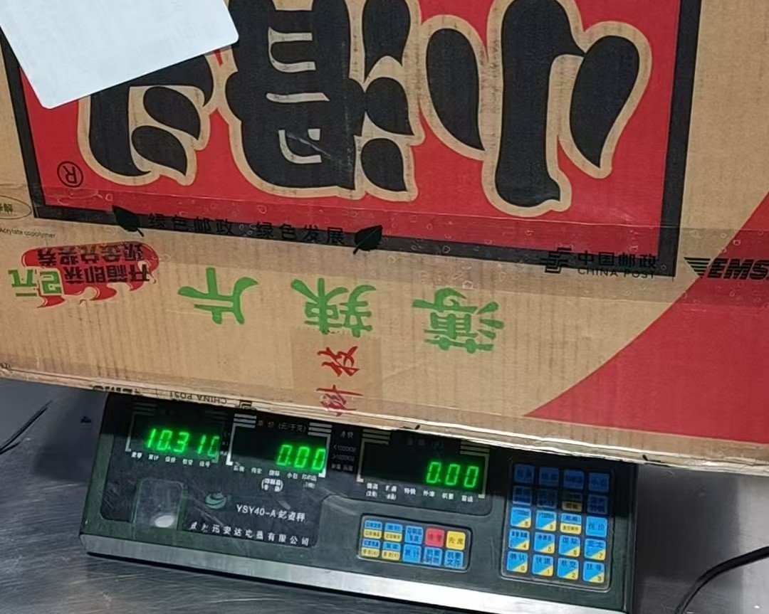 The luggage package on a China Post scale at the Chongqing hotel, weighed for a shipping quote