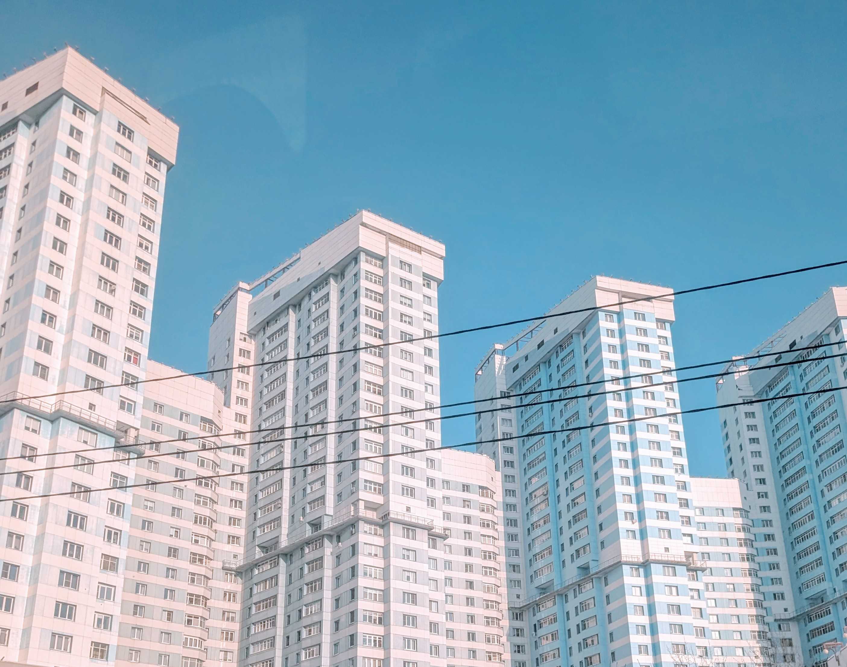 White high-rise buildings against a blue sky in Moscow on the morning of arrival